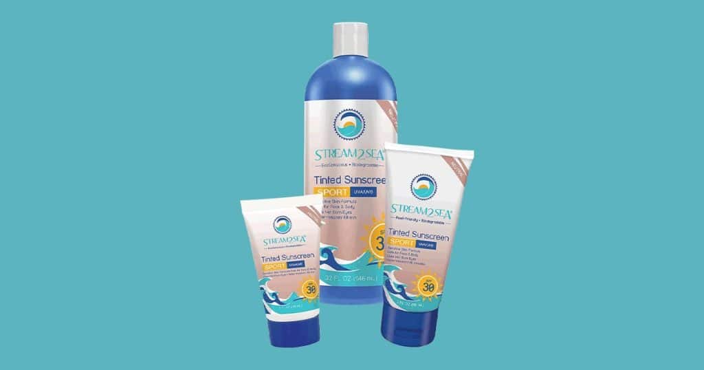 Trois crèmes solaires teintées SPF 30 de Stream2Sea de tailles différentes, sur fond bleu pastel.