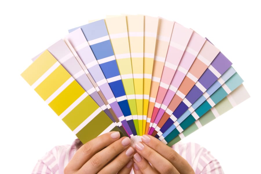 A woman holding up different colour palette strips.