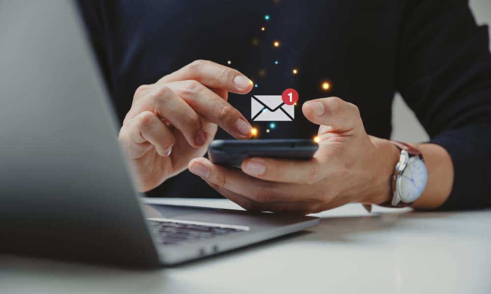A male model using his phone with a pop up animated logo of an inbox with a notification