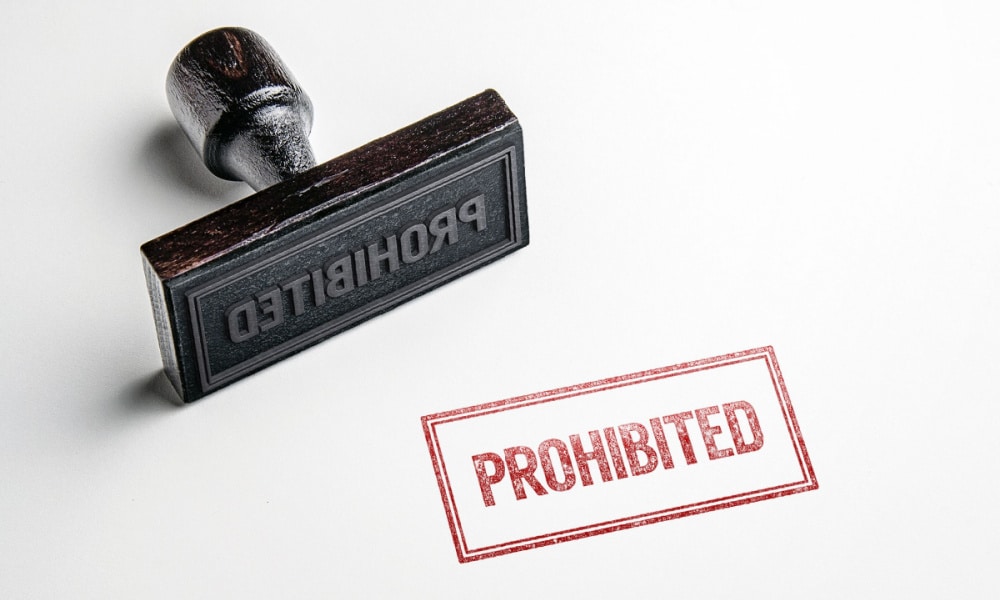 A wooden stamp and a stamped text indicating “Prohibited”