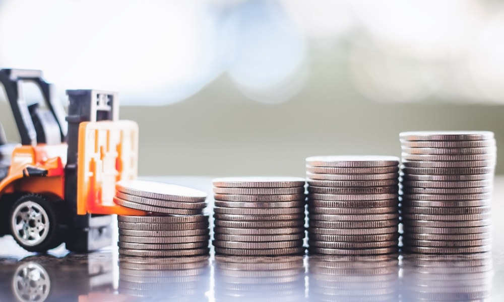 A miniature forklift and a stack of coins