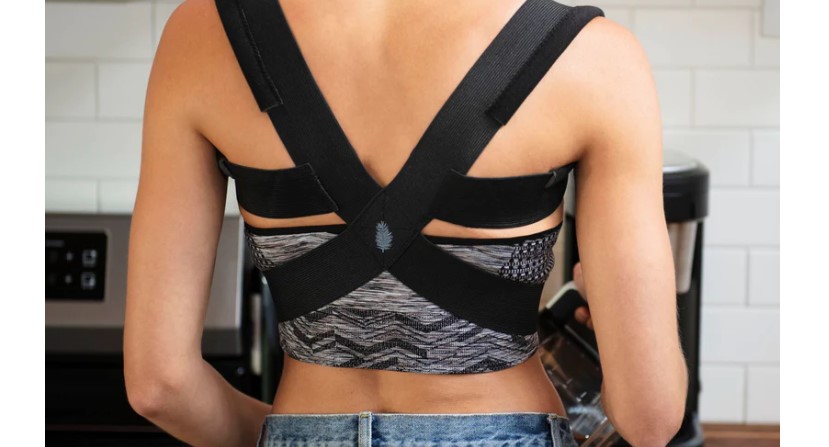 A woman wearing a black Berlin & Daughter Posture Corrector.