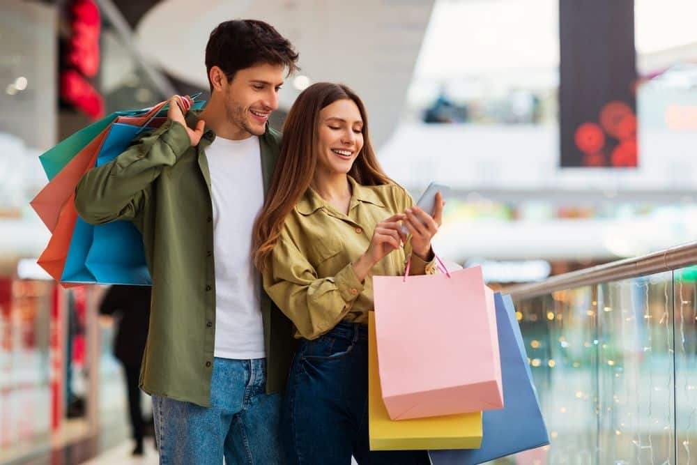 man and women holding shopping bags
