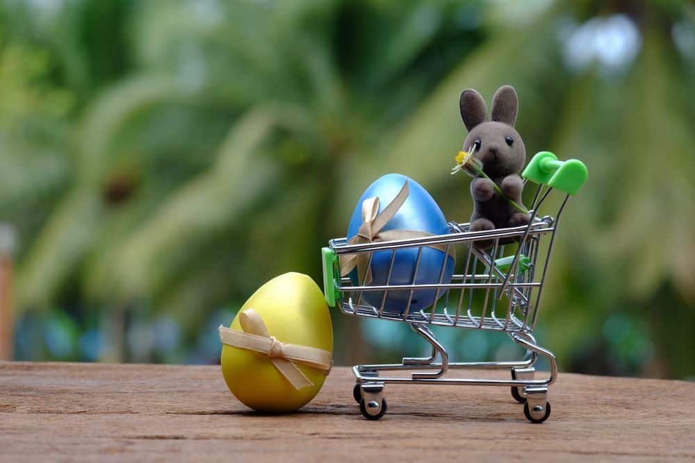 A bunny and easter eggs on a miniature shopping cart