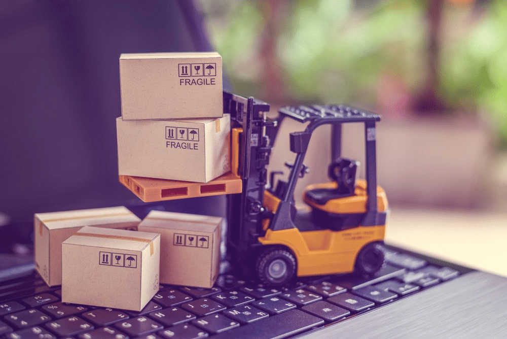 a toy forklift lifting package boxes on a keyboard