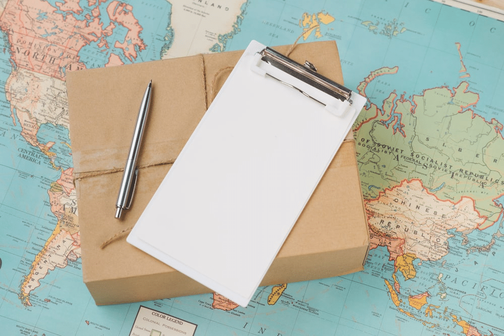 a world map and a cardboard box with a pen on top of it