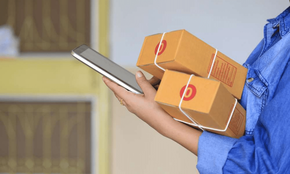 Person holding smartphone and boxes.