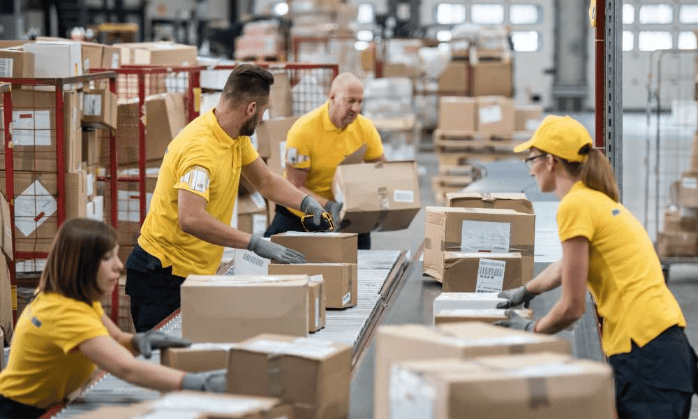 Workers sorting packages in a warehouse.