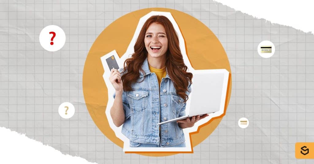 A woman holding a credit card and a laptop