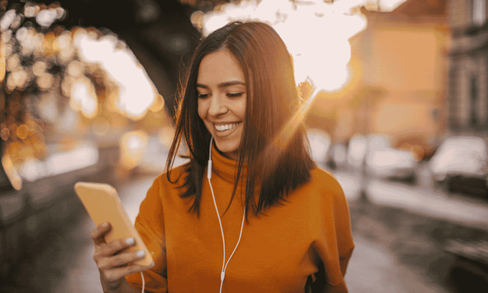 A girl smiling while looking at her phone.